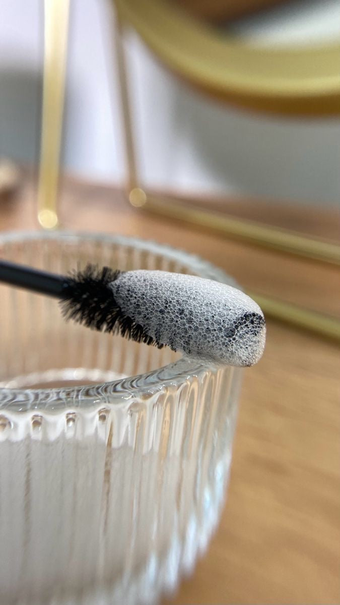 Pose d'extensions de cils par une lash tech avec les produits Maison Moon. Une brosse pour les cils profesionnel avec du nettoyant