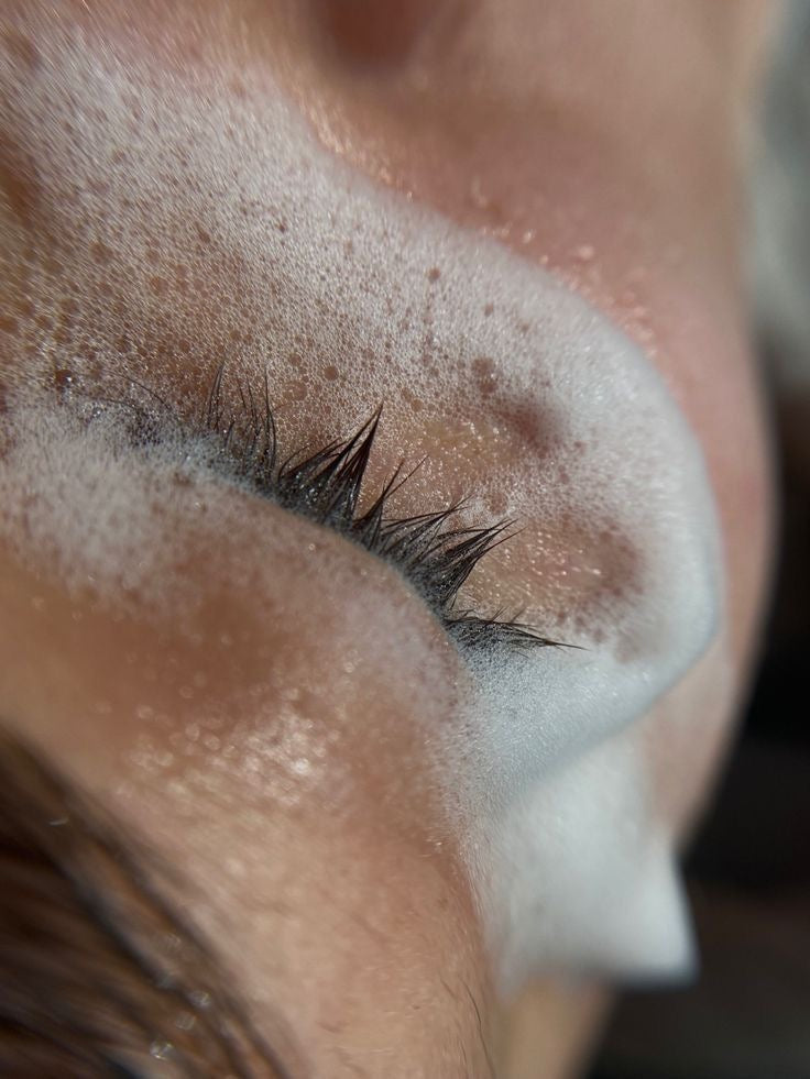Pose d'extensions de cils par une lash tech avec les produits Maison Moon. Un shampoing pour cils nettoie les cils de la cliente